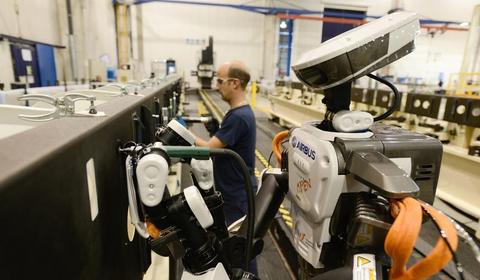 OUvrier et robot dans une usine