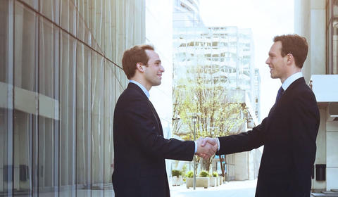 Hommes en costumes se serrent la main