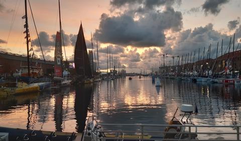 Voiliers de la course Transat Jacques Vabre à quai dans la marina, au soleil couchant