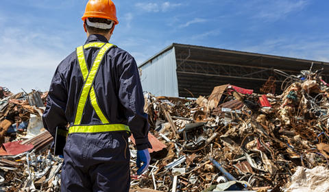 Un opérateur de dos dans un centre de traitement des déchets.