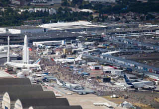 Vue aérienne du Salon du Bourget : la foule des visiteurs se promenant parmi les avions et les fusées