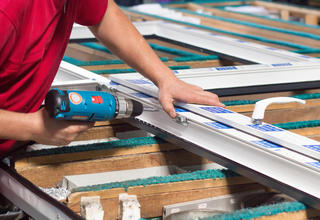 Un artisan à l'assemblage d'une menuiserie aluminium