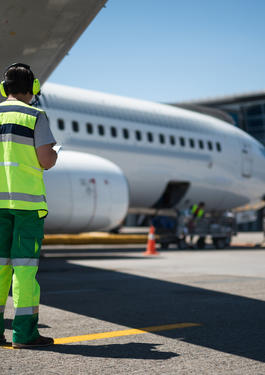 Deux agents aéroportuaires au travail sur le tarmac d'un aéroport.