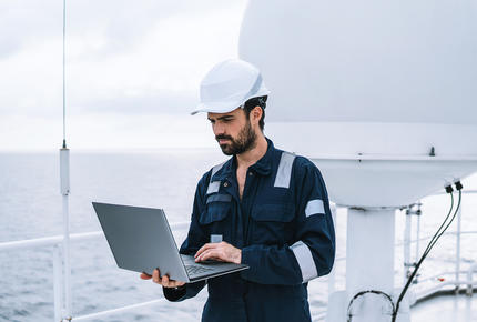 Un technicien opérant des mesures de contrôle sur le pont d'un navire.